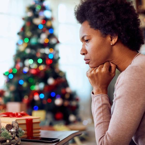 woman thinking of something while spending Christmas alone at home
