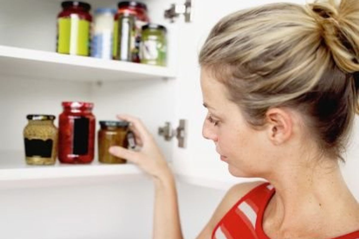 woman tidying up kitchen pantry