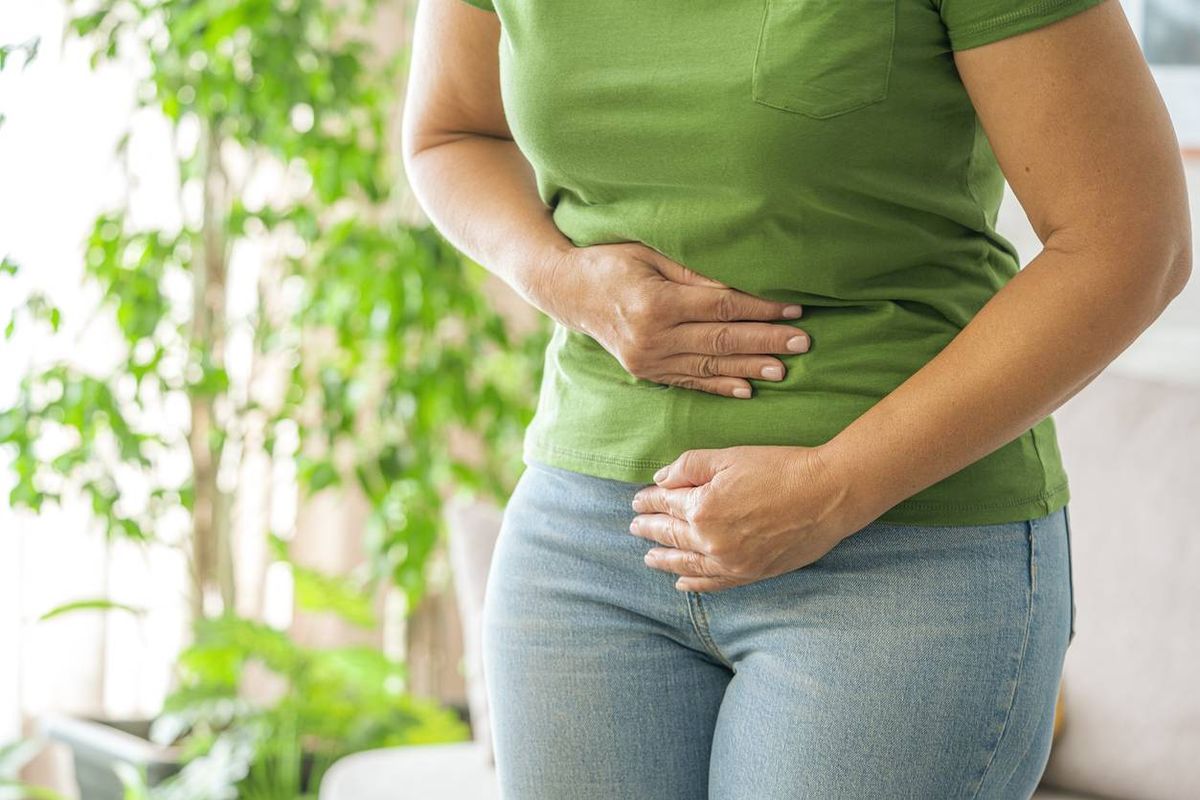 Woman touching her stomach experiencing abdominal pain
