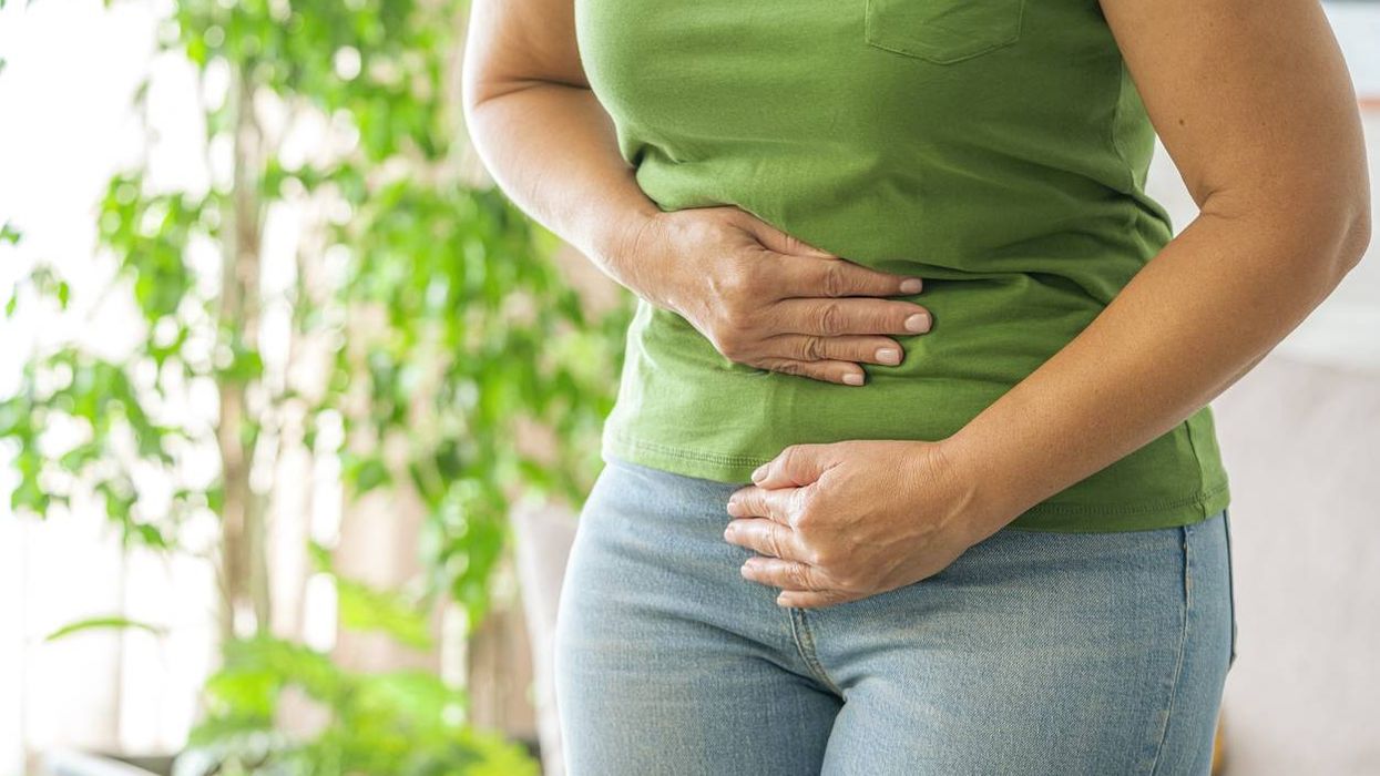 Woman touching her stomach experiencing abdominal pain
