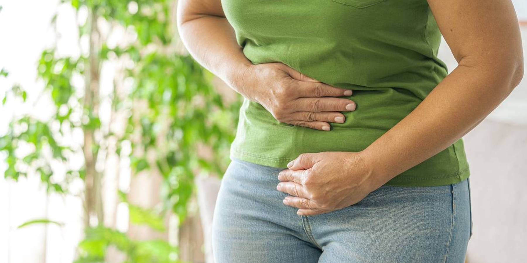 Woman touching her stomach experiencing abdominal pain