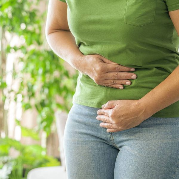 Woman touching her stomach experiencing abdominal pain