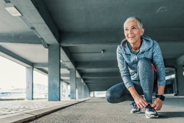 woman tying her shoes to go running