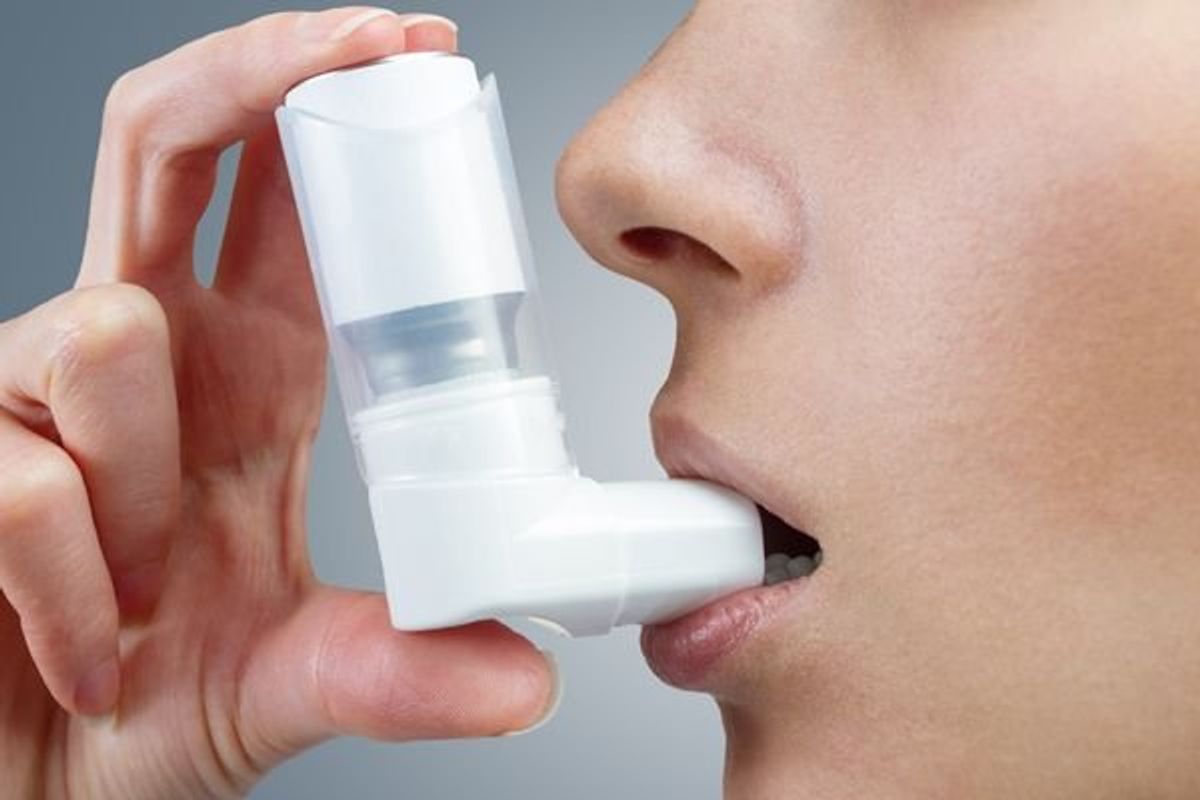 woman using an inhaler for asthma