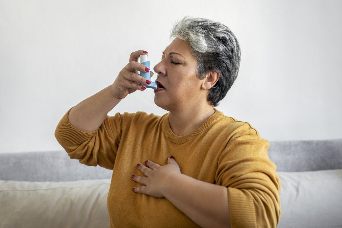 Woman using asthma inhale