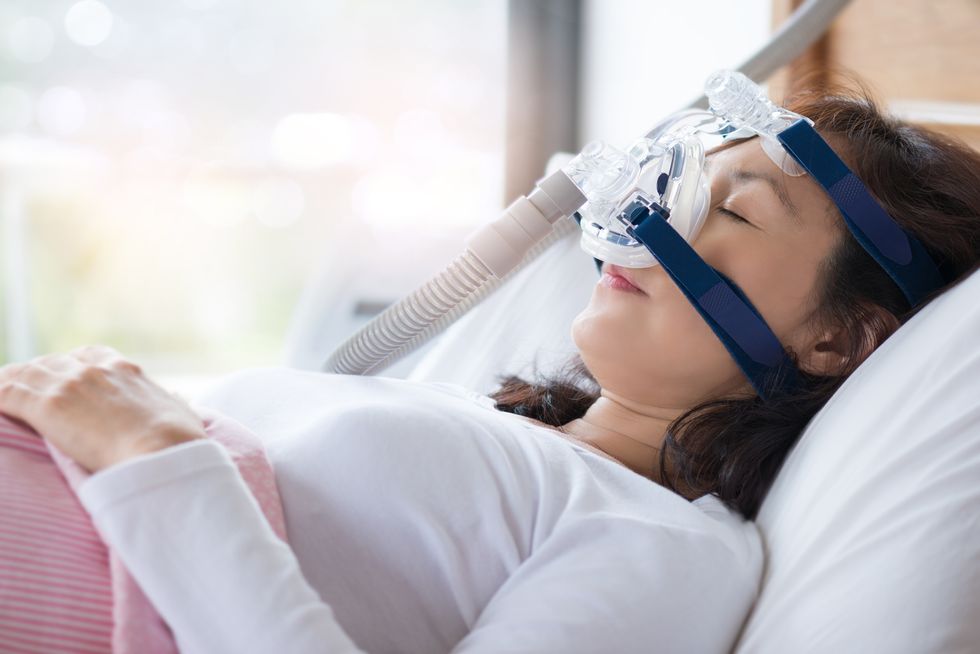 woman using cpap machine to stop choking and snoring from obstructive sleep apnea