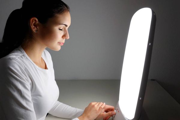 woman using Light therapy lamo at home for SAD Light Therapy