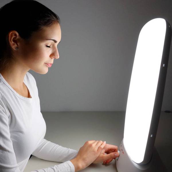 woman using Light therapy lamo at home for SAD Light Therapy