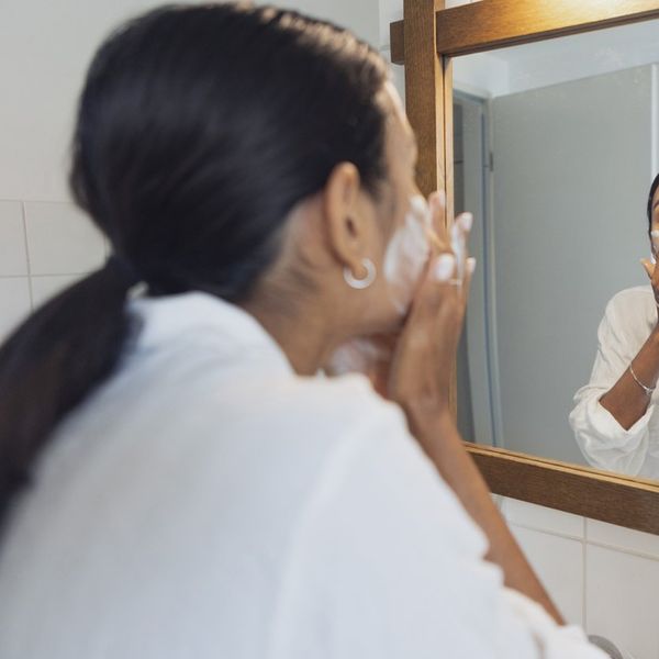 Woman washing face and looking in mirror