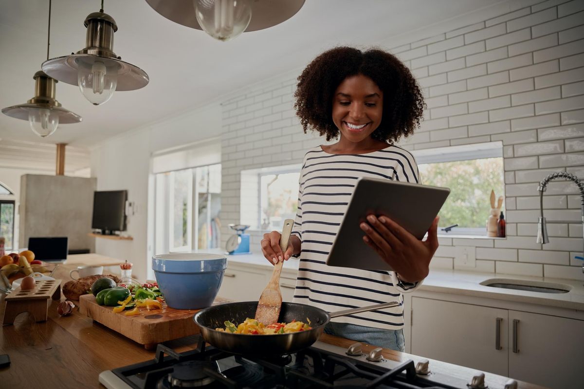 woman watching recipe in digital tablet while cooking