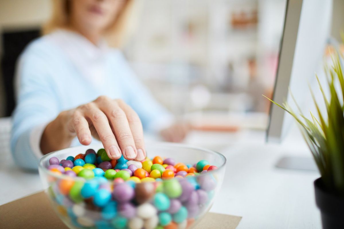 woman with a sugar habit eating candy from a bowl
