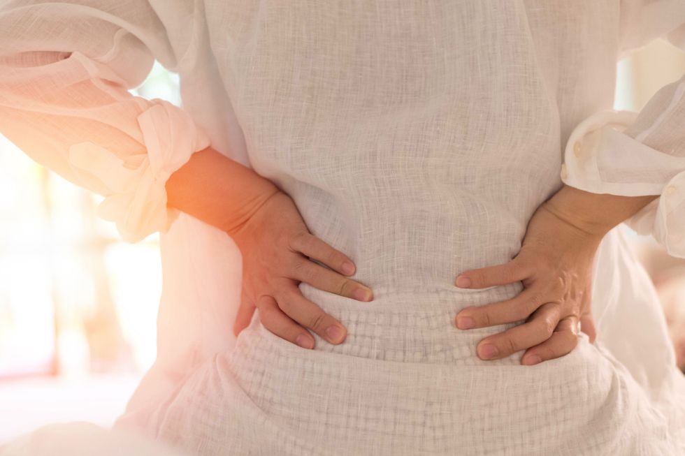 woman with back pain due to a Vertebral Compression Fracture