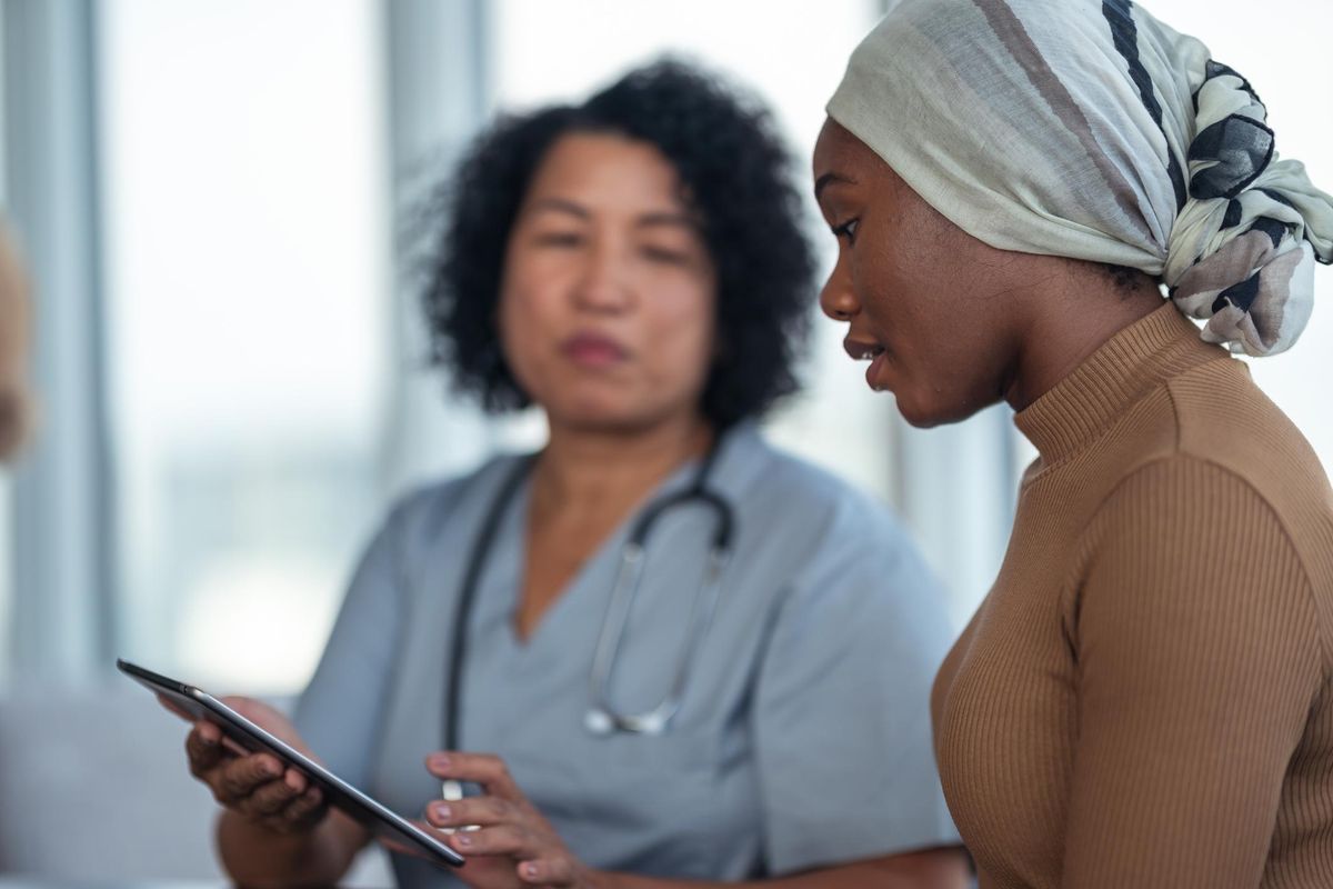 Woman with cancer reviews test results with doctor
