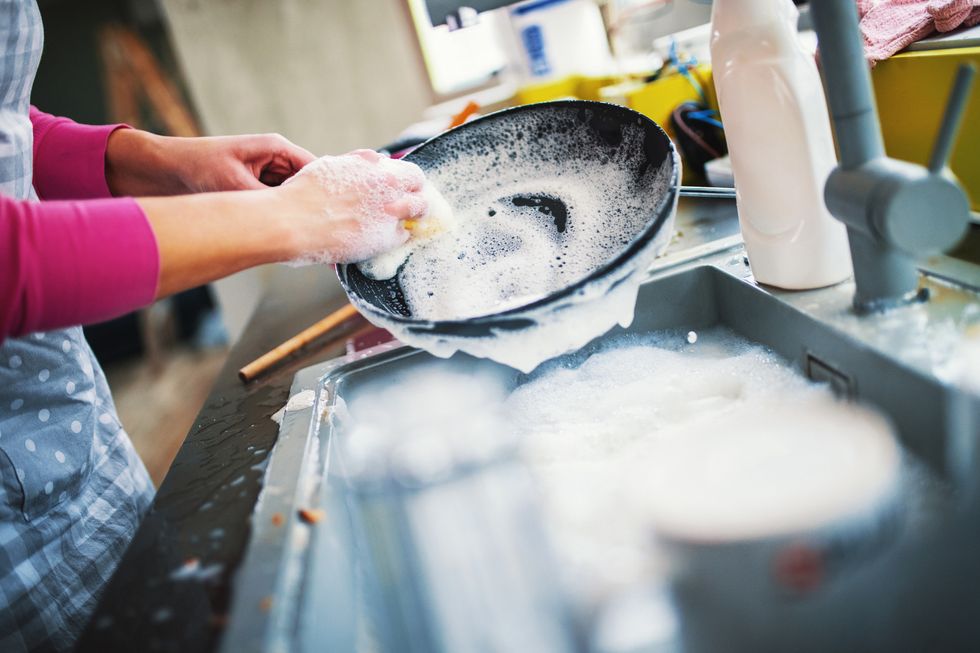 woman with chronic pain washing dishes