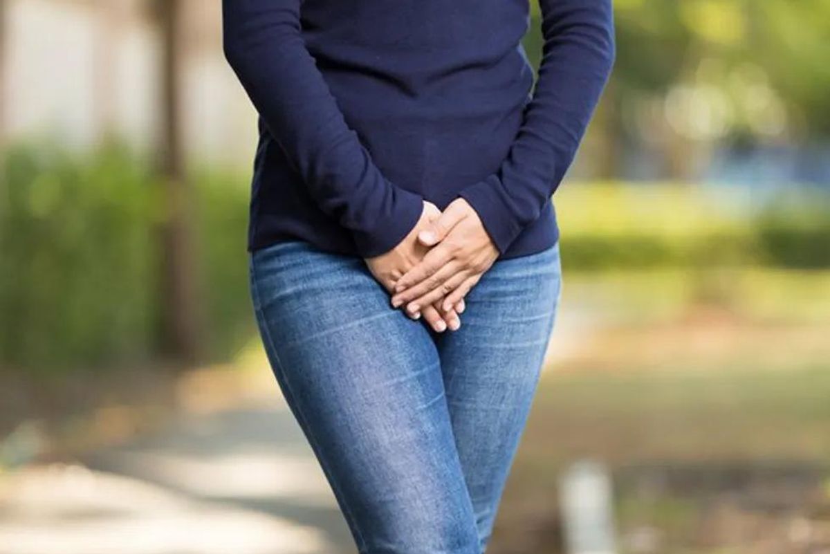 woman with her hands over her bladder