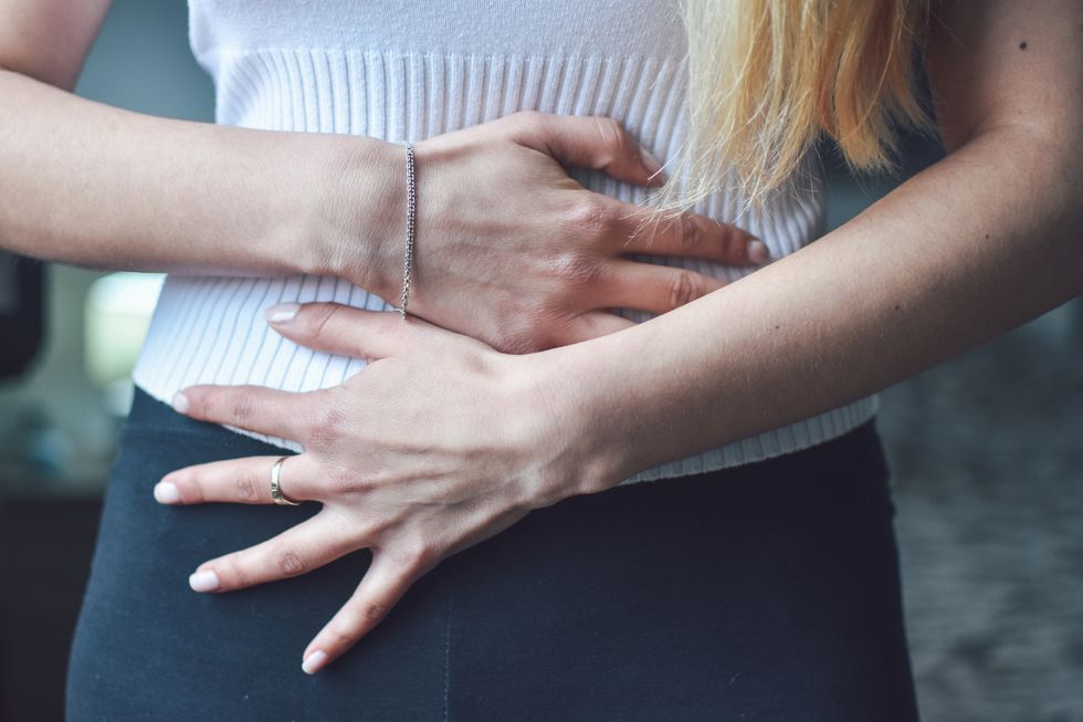 woman with her hands over her stomach