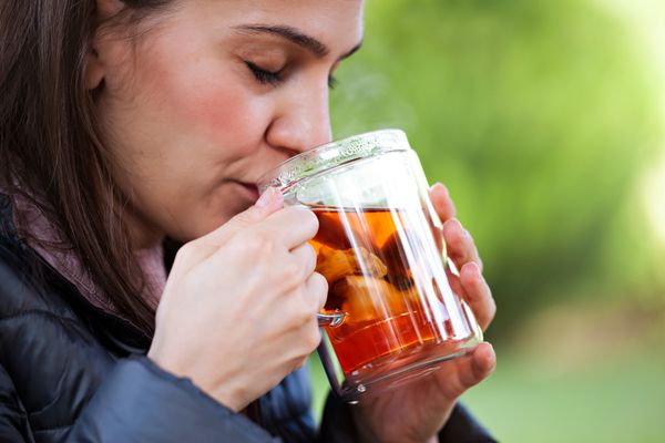 woman with herbal tea cup outdoors