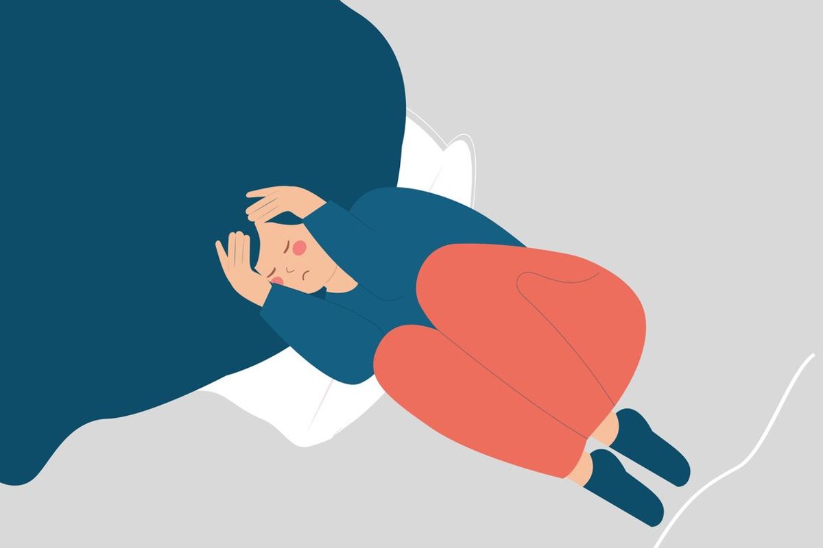 woman with insomnia on bed covering her face