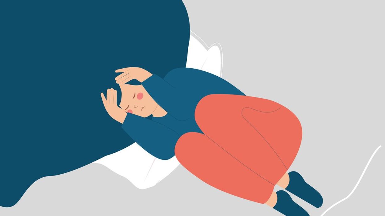 woman with insomnia on bed covering her face