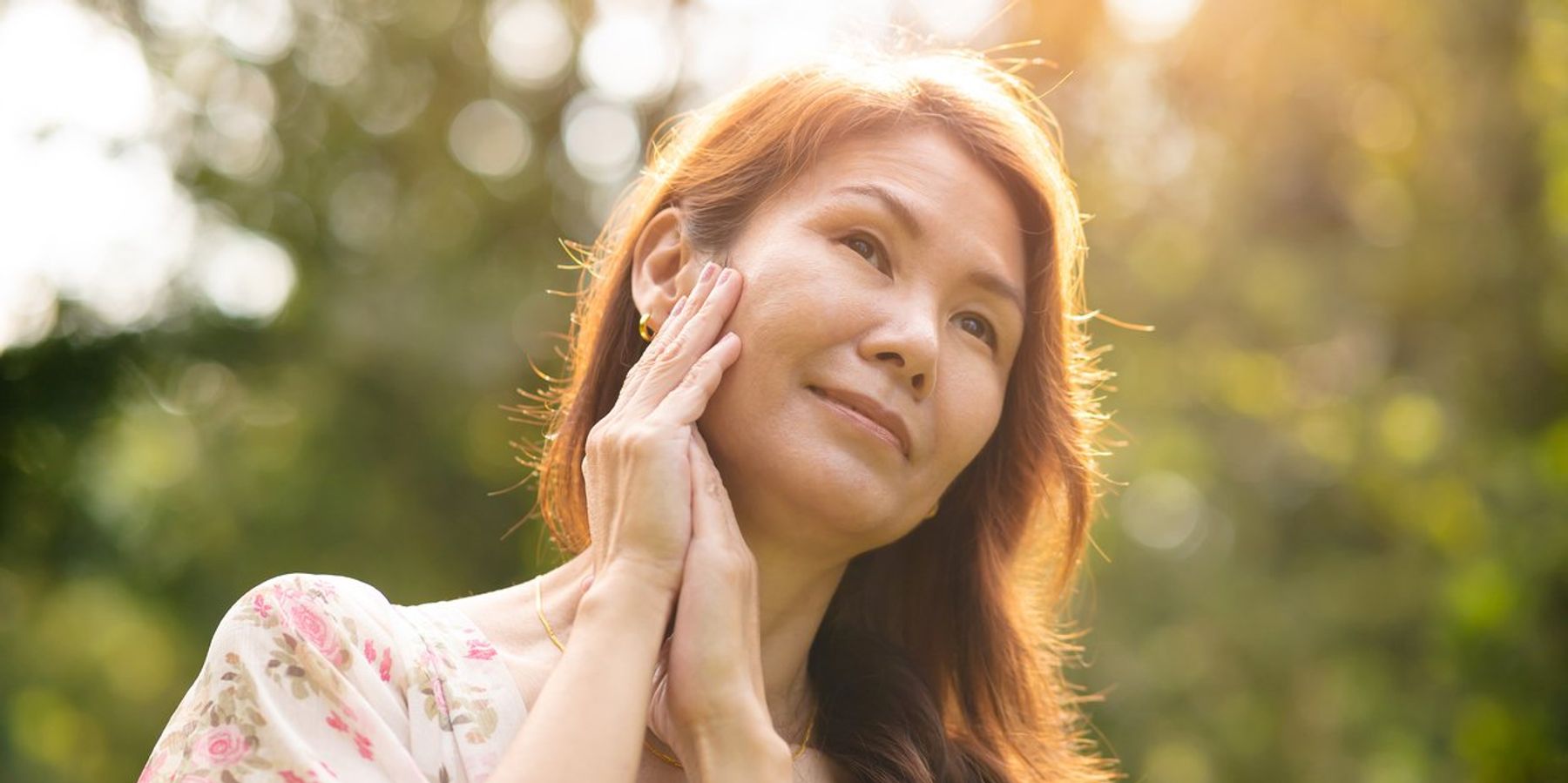 Woman with rare disease holding hands to face