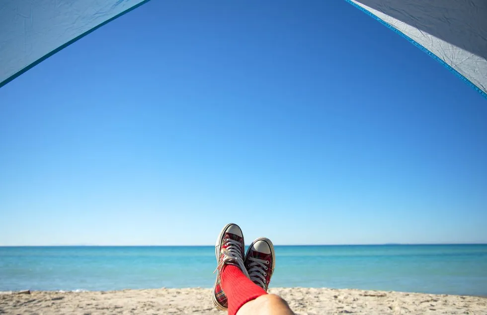 Woman with shoes relaxing by the sea