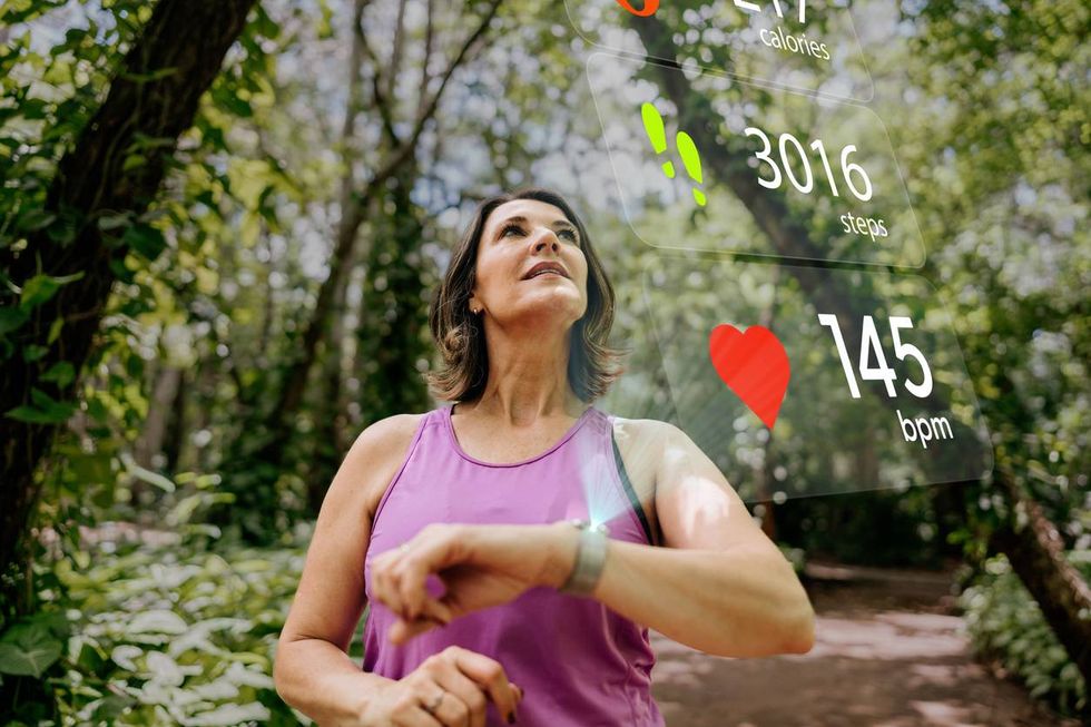 woman with smart watch looking at sports infographic hologram on the public park