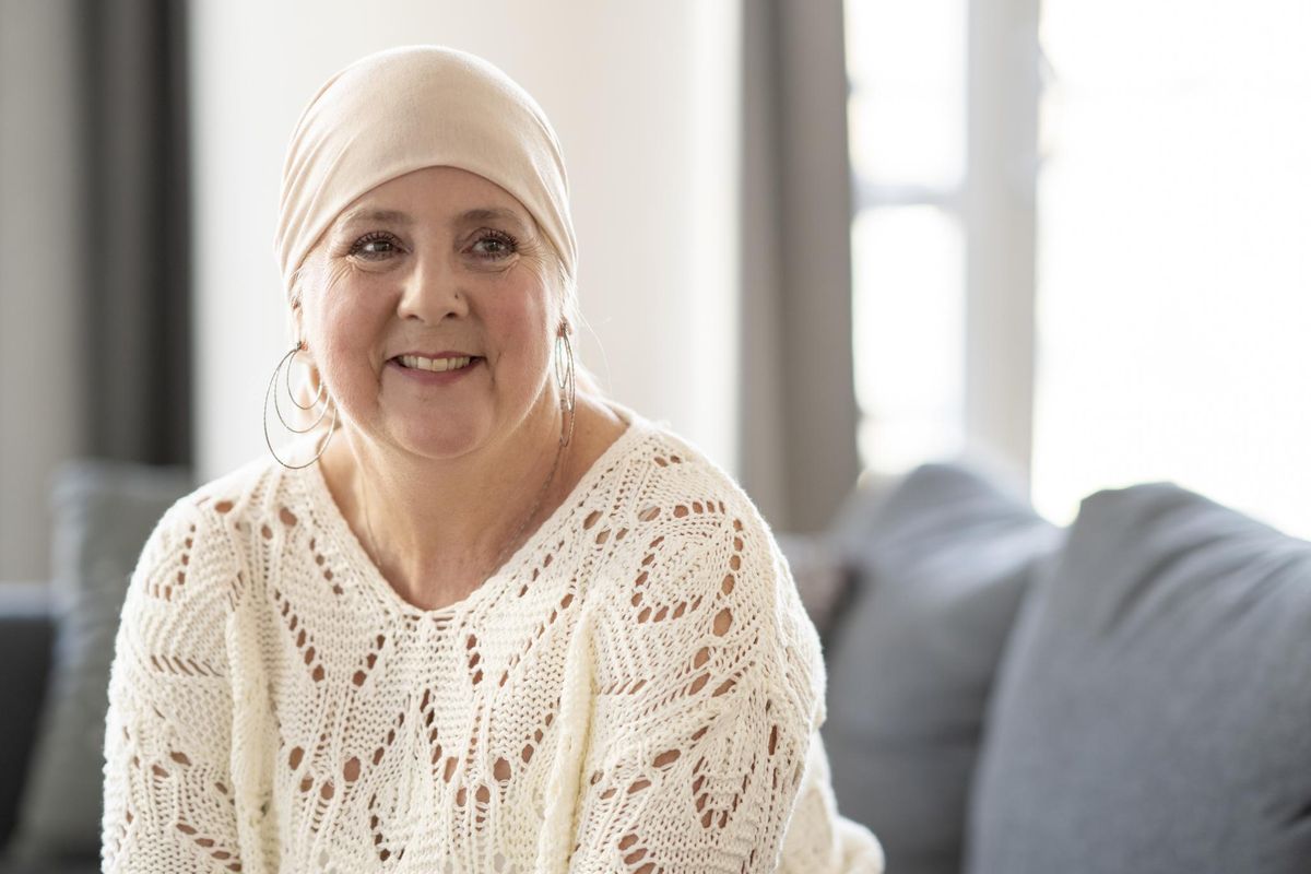 woman with Urothelial Bladder cancer, sits on her sofa posing for a portrait