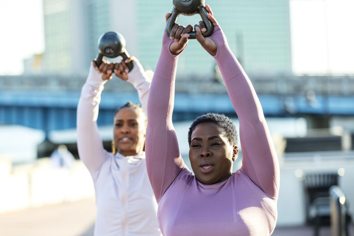 women in city exercising, kettlebells