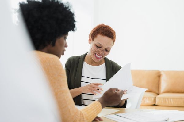 Women Reviewing Documents Together in Office