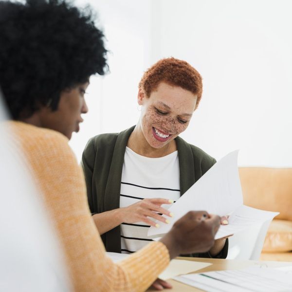 Women Reviewing Documents Together in Office