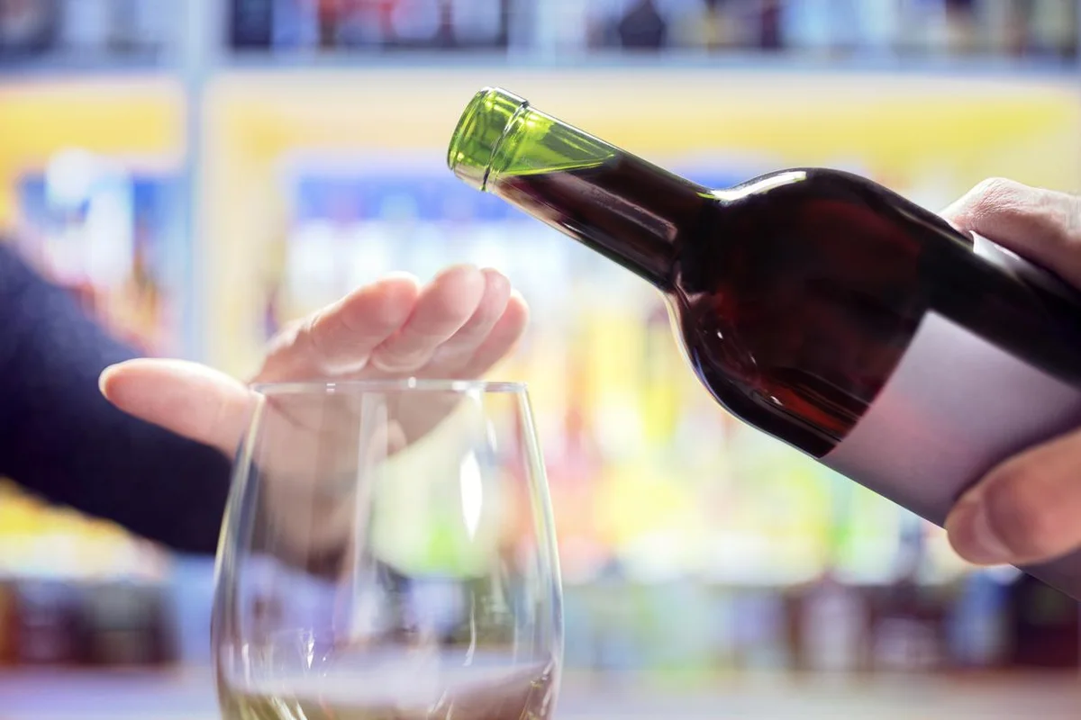 Women's hand covering a wine glass to stop the wine from being poured in.