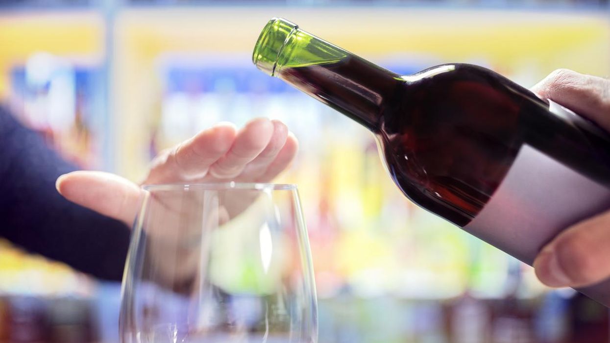 Women's hand covering a wine glass to stop the wine from being poured in.