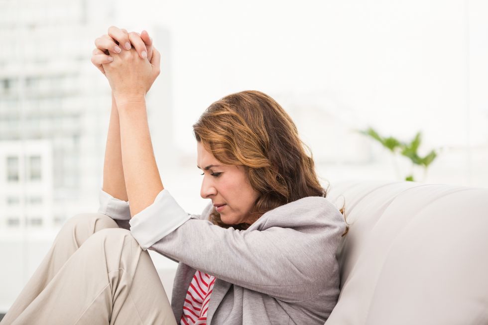 Women sitting on the couch suffering from anxiety