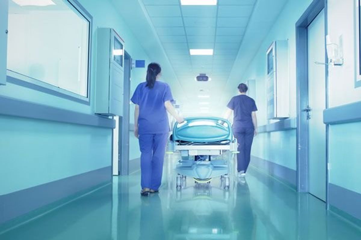 women walking a gurney down a hospital hallway waiting for a surgery