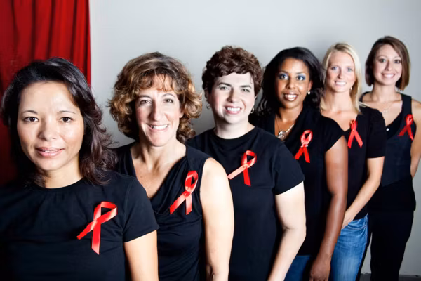 women wearing black shirts with aids awareness red ribbons