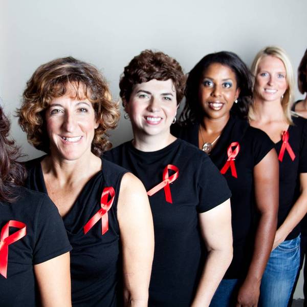 women wearing black shirts with aids awareness red ribbons