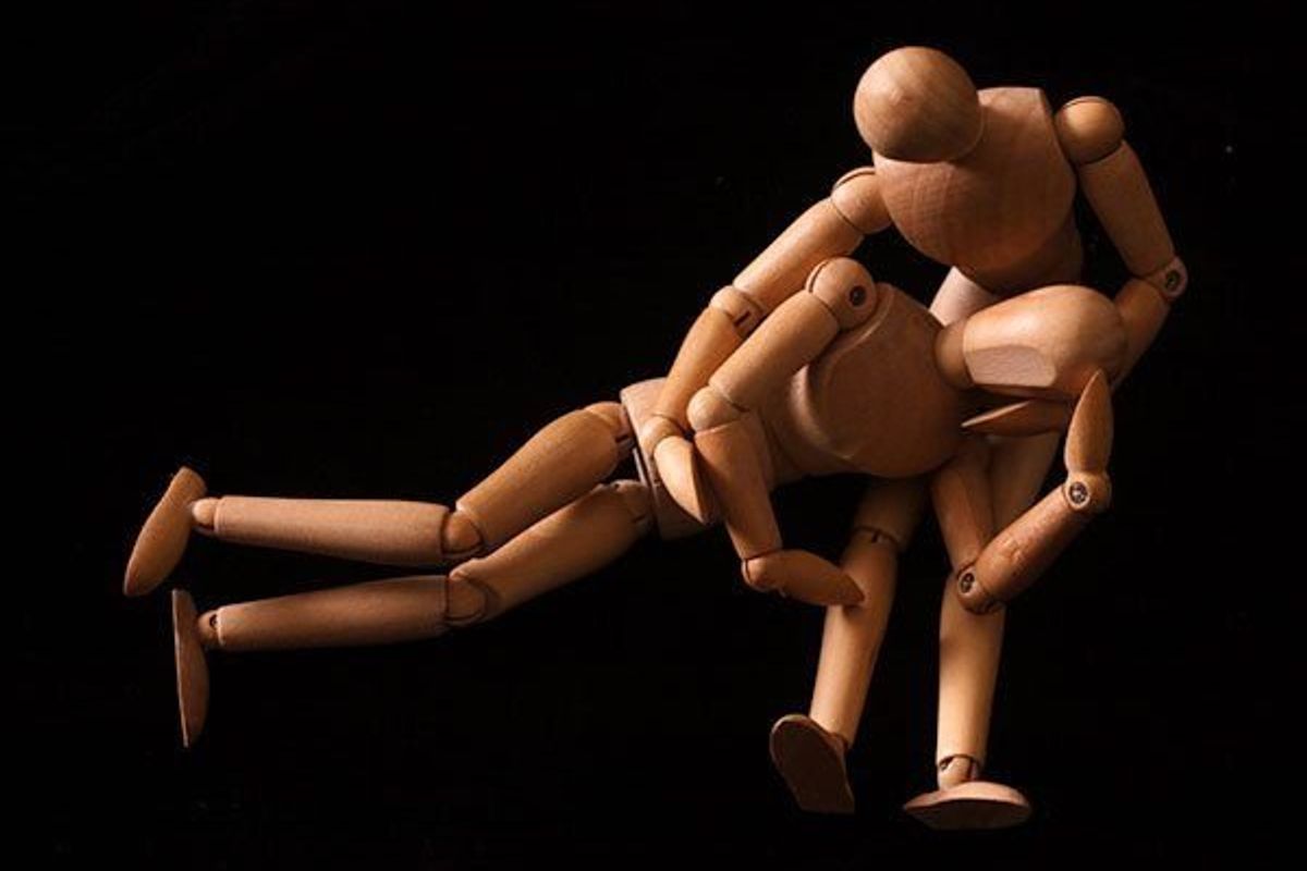 wooden figurines holding each other