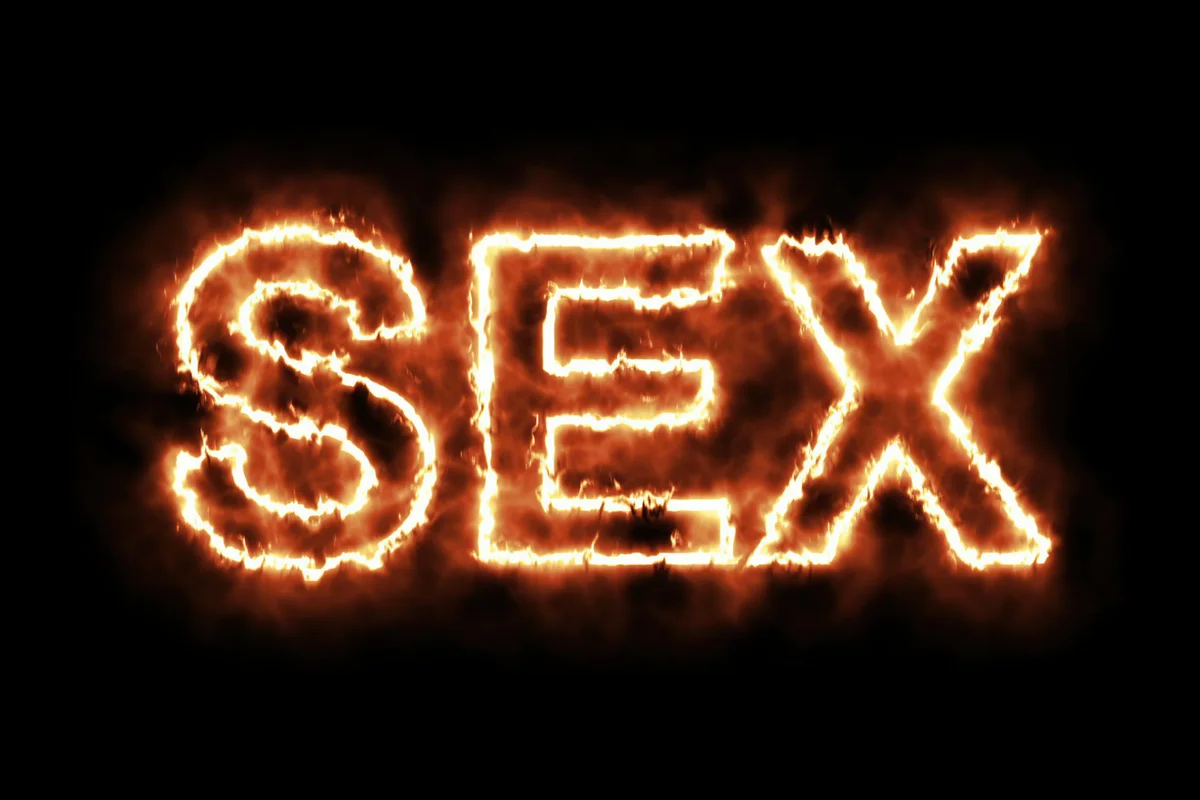 word SEX burning on fire on black background