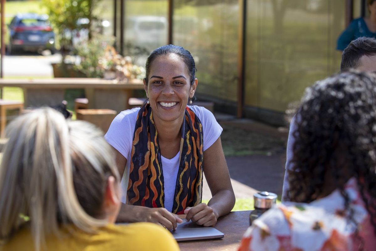 young aboriginal students studying together outdoors in the sun in Australia