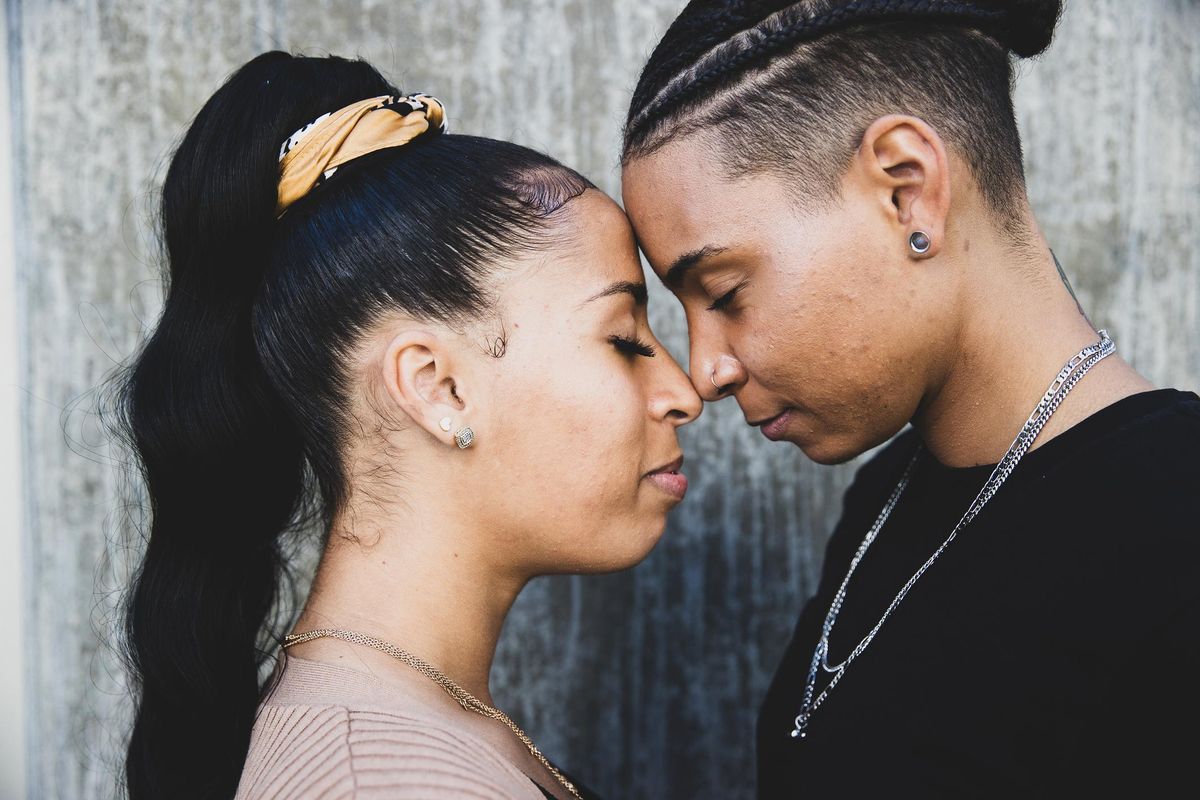 Young African American lesbian couple touch foreheads