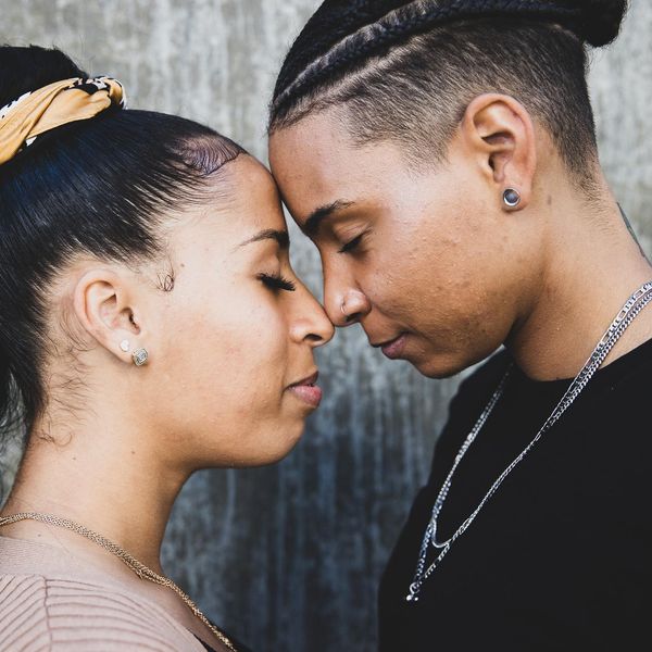 Young African American lesbian couple touch foreheads