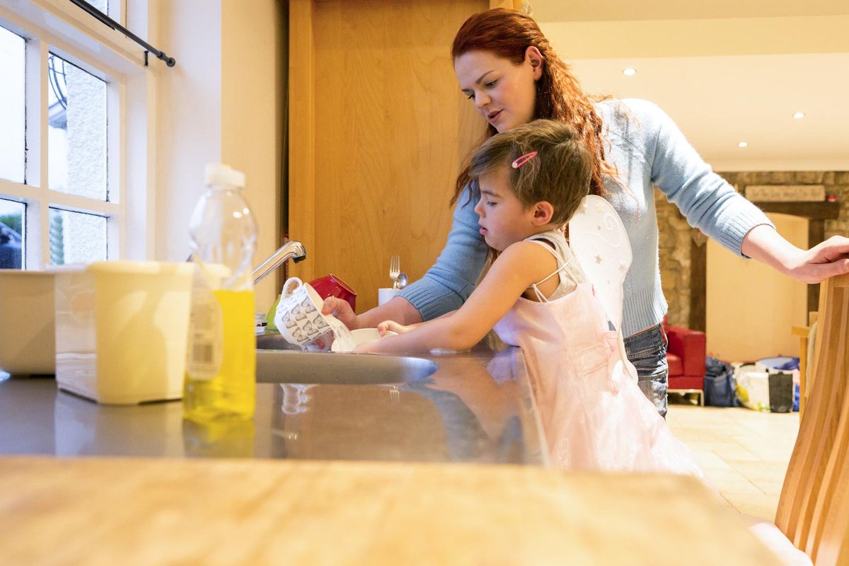 Young Boy Dressed in a Fairy Costume Doing Chores