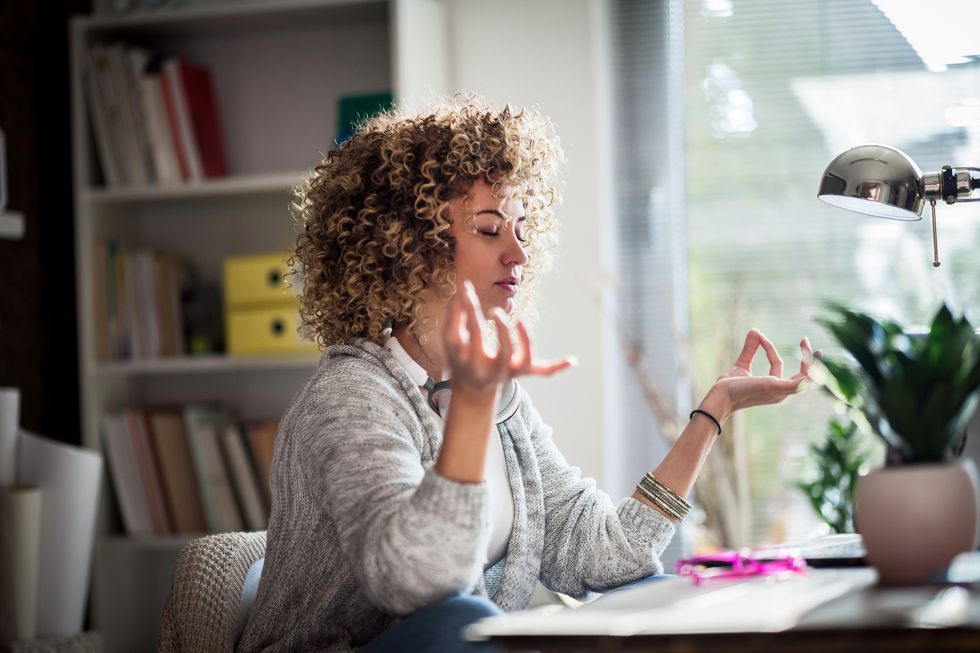 young businesswoman meditating in her office