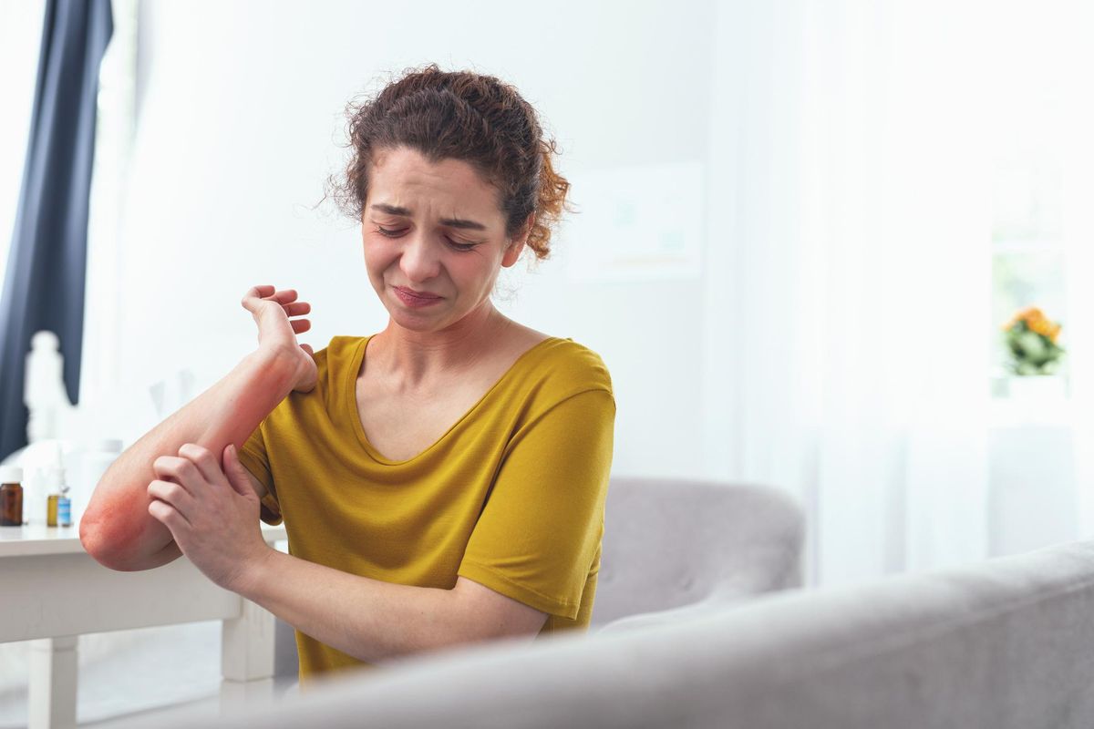 Young girl desperately scratching her arm