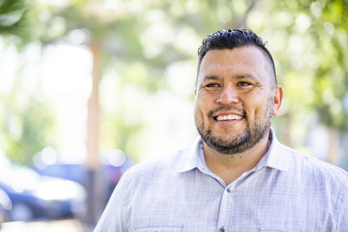 young hispanic man smiles outdoors