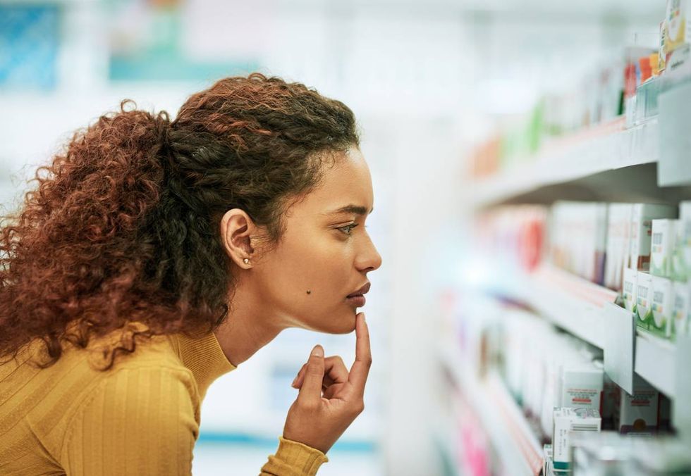 young woman browsing the shelves of a pharmacy