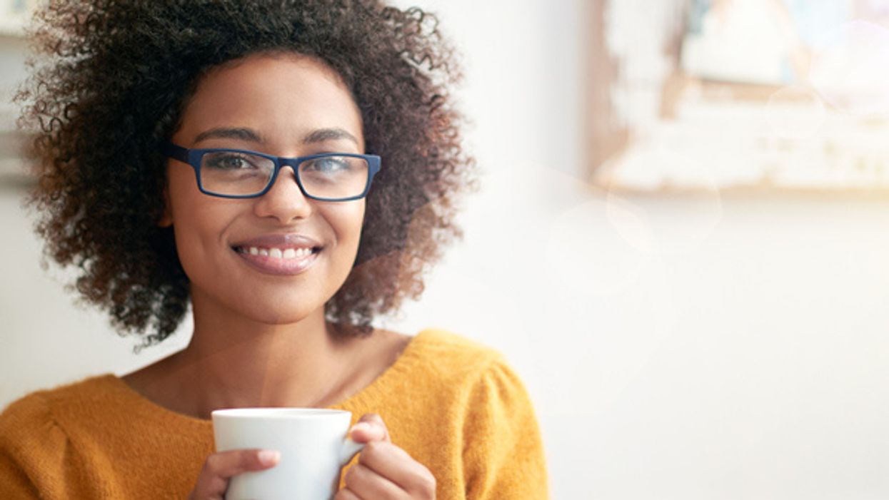 young woman drinking a cup of coffee at home