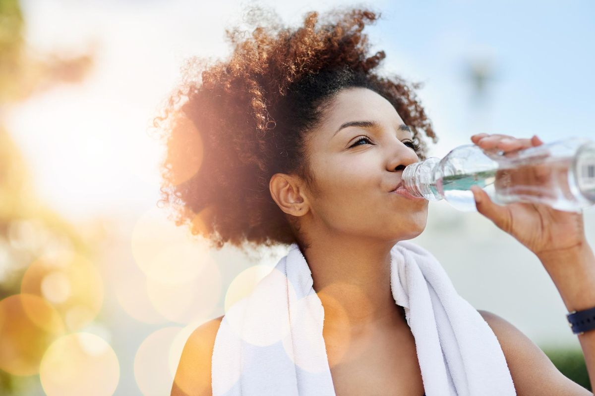 young woman enjoying a bottle of water while out for a run