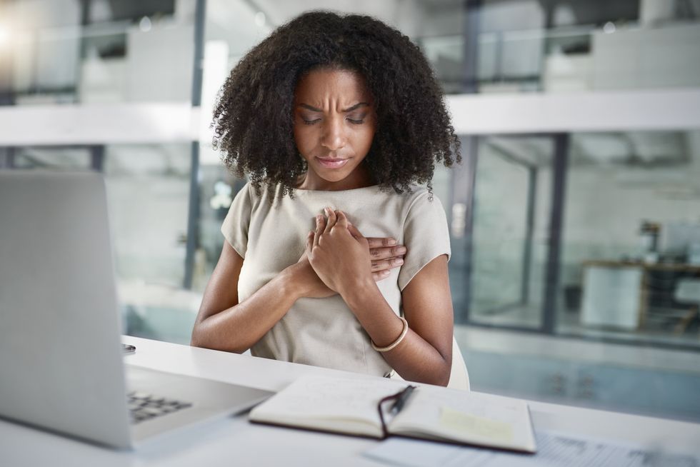 young woman having a heart attack at work