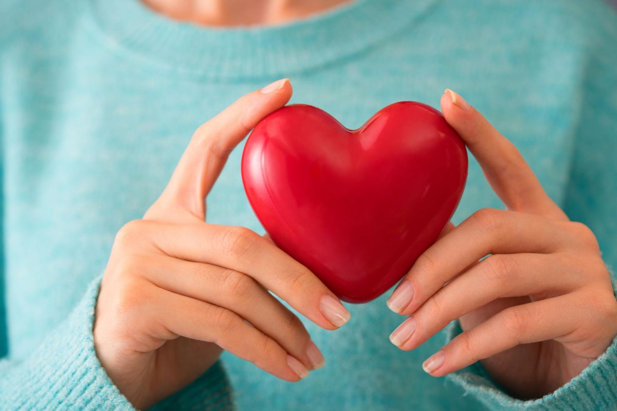 Young woman holding red heart